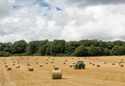 Feldarbeit mit dem Traktor in England Feld mit Heuballen in England