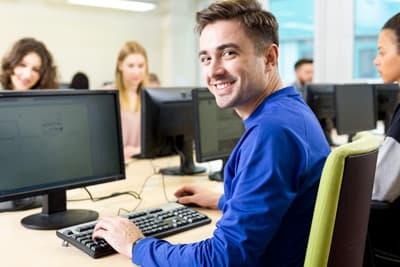 MINT-Absolventen, die an der Schnittstelle zwischen Informatik und BWL arbeiten möchten, benötigen neben IT-Kenntnissen auch Management-Kompetenzen. Student am Computer in einem Computerraum