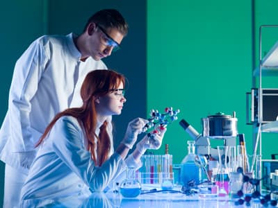 Viele ausländische Hochschulen sind im Bereich Materialwissenschaft sehr gut aufgestellt. Sie bieten spannende Teildisziplinen und eine erstklassige technische Ausstattung. Zwei Forscher untersuchen ein Molekülmodell im Labor.