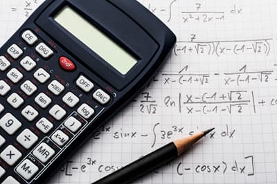 Viele Mathematikstudenten teilen eine gemeinsame Faszination für die Welt der Zahlen und Formeln. Taschenrechner auf einem mit mathematischen Formeln beschriebenen Blatt Papier