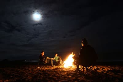 Lagerfeuer-Romantik am Strand von Kaikura Marvin und seine Freunde sitzen um ein Lagerfeuer am Strand