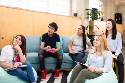 Studieren an der UTS Eine Gruppe junger Studierender auf Sofas und Sitzkissen