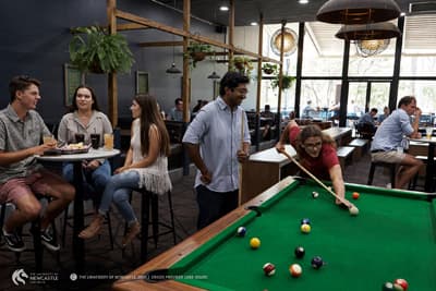 Der moderne Campus bietet diverse Freizeitmöglichkeiten. Studierende treffen sich zum Billiard spielen.