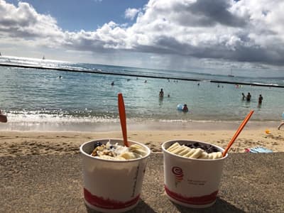 Sonne, Strand und Frozen Banana! Frozen Banana im Becher vor Strandpanorama in Kalifornien