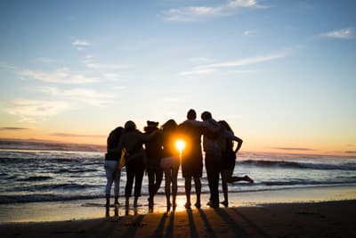 Immer wieder wunderschön Studenten beobachten den Sonnenuntergang am Strand