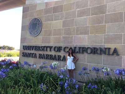 An der UCSB ist für jeden das passende Studienangebot dabei. Studentin vor dem Logo der UCSB