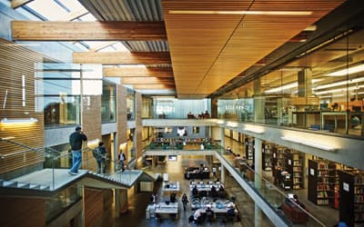 Die Universitätsbibliothek Bibliotheksräume über drei Etagen mit einer Treppe an der linken Wand.