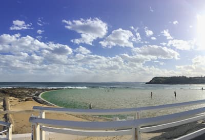 Welcome to the sunny side of life! Sonniger Tag in den Newcastle Oceanbaths: Hinter einer weißen Reling beginnt das vom Meer abgetrennte Meerwasserbecken.