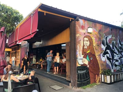 Beliebter Ausgehspot in Newcastle: Die Darby Street Kioskartiges Street-Café auf der Darby Street mit Graffiti, das einem Kaffee trinkenden Jesus ähnelt.