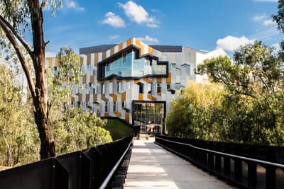 Die optimale Kombination aus Natur und Moderne: Die La Trobe University Weg mit Bäumen zum Gebäude der La Trobe University