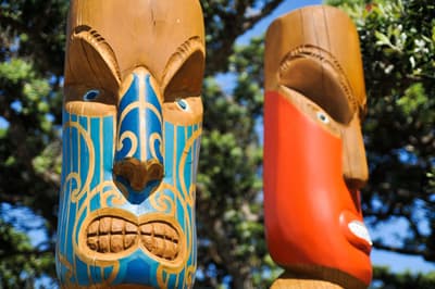 Eine neue Kultur kennenlernen! Zwei Maori-Holzschnitzereien in Form von finster dreinblickenden Kriedern