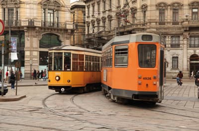 Prächtig und charmant: Mailands Straßen Zwei historisch aussehende Straßenbahnen begegnen sich in den mit prachtvollen Altbauten gesäumten Straßen Mailands