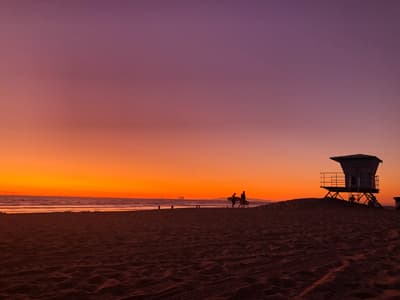 Tolle Aussichten! Spektakulärer orange-lilafarbener Sonnenuntergang am Strand.