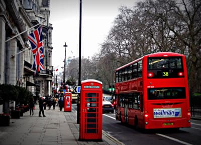 London calling! Roter Doppeldeckerbus, rote Telefonzelle und britische Flaggen die an der Fassade einer Altbauvilla hängen.