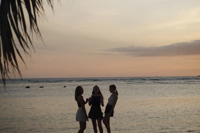 Das Beste von allem Silhouetten von drei Studentinnen am Strand kurz nach Sonnenuntergang