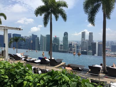 Singapurs Downtown Area geizt nicht mit spektakulären Attraktionen Blick über die Stadt vom Rooftop des Marina Bay Sands. Auf dem Dach des Hotel gibt es sogar einen palmengesäumten Pool, aus dem heraus man den Ausblick genießen kann.