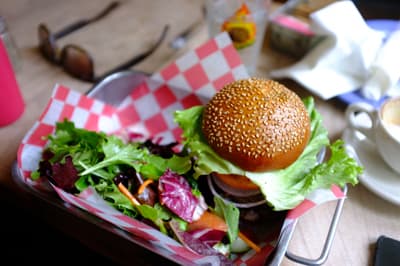 Yummy! Burger auf einem kleinen Metalltablett mit rosa-weiß karriertem Papier
