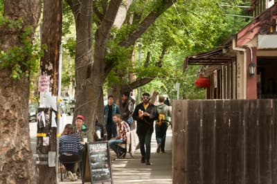 Studentenstadt Davis Studierende sitzen in Cafés an einer mit Bäumen gesäumten Straße in Davis