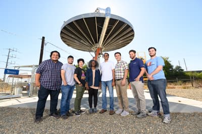 Superhelden von morgen Studenten mit ihrem Professor vor einem Ufo-ähnlichen Gebäude