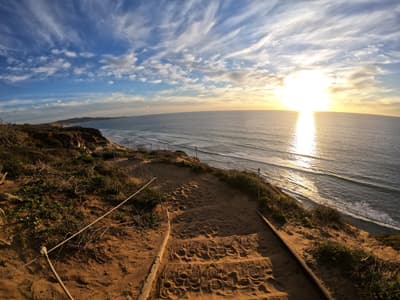 Weg der zum Strand hinunterführt bei Sonnenuntergang