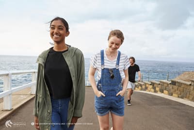 Entspannt, günstig und nah an der Natur! Gutgelaunte Studierende der Uni gehen spazieren gemeinsam die Küstenpromenade entlang.
