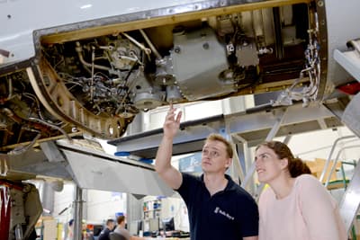 Mehr als nur Theorie Eine Studentin lässt sich den komplizierten mechanischen Aufbau eines Flugzeugs vonn innen zeigen.