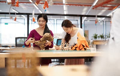 Zwei Studentinnen arbeiten an Modellen aus verschiedenen Materialien.
