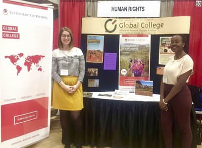 Einzigartiger Studiengang Zwei Studentinnen stellen mit einem Stand das Global College und den Bachelor of Human Rights vor.