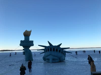 Das Sportangebot in Madison macht auch im Winter keinen Halt! Eisfläche mit Schlittschuhläufern und Freiheitsstatue, die aus dem Eis guckt