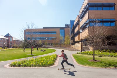 Die North Park University zieht viele internationale Studierende an. Student fährt Skateboard auf dem Campus der North Park University