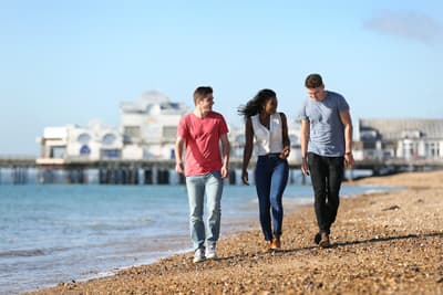 Ganz entspannt ins Auslandssemester Studierende spazieren am Strand von Portsmouth entlang