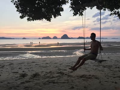 Wenn du mal eine Auszeit von der Hektik der Großstadt brauchst... Person auf einer Schaukel am Strand