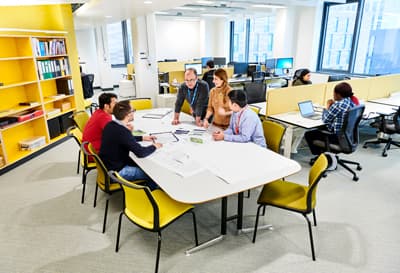 Eine kleine Gruppe Studierender und ein Dozent bei einem Prokekt