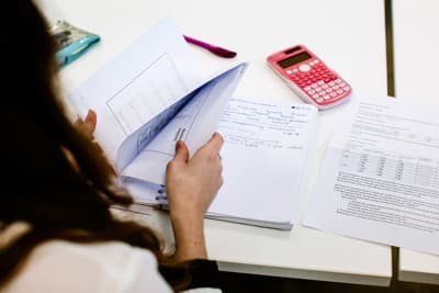 Lerne, Projekte erfolgreich zu managen Eine Studentin beim Planen und kalkulieren eines Projektes.