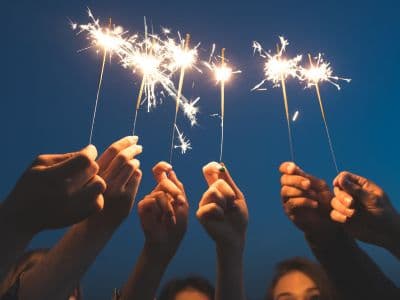 Feiere zusammen mit deinen Kommiliton:innen Silvester am Times Square Hände mit Wunderkerzen