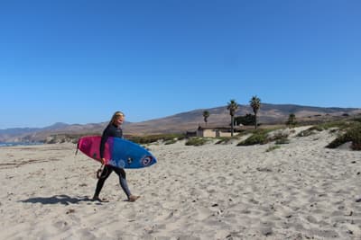 Bewirb dich jetzt für den Sommer deines Lebens! Surferin am Strand in Kalifornien