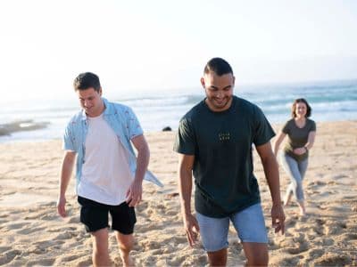 In Newcastle kannst du neue Leute treffen und viele Abenteuer erleben. Junge Leute am Strand von Newcastle