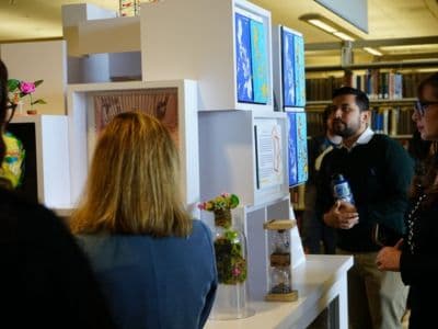 Eine Kunstausstellung zum Thema Nachhaltigkeit an der CSUSM Menschen vor einer modularen Kunstausstellung