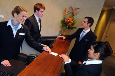 Studierende der Blue Mountains International Hotel Management School an der Hotelrezeption Studenten an der Rezeption eines Hotels